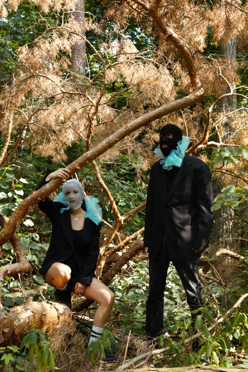 two people in the forest wearing balaclavas